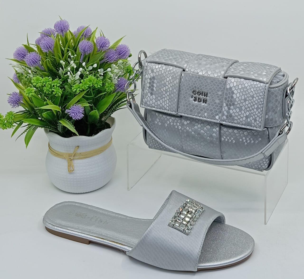 Stylish Matching Set – Includes a trendy shoulder bag and elegant slip-on sandals in coordinating silver tones.